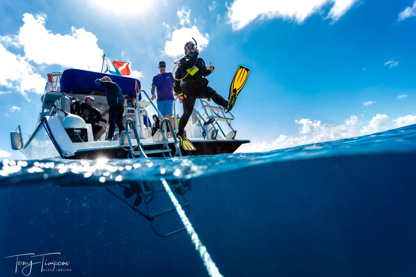 Scuba diver giant-striding off the dive boat into bright blue Florida Keys water