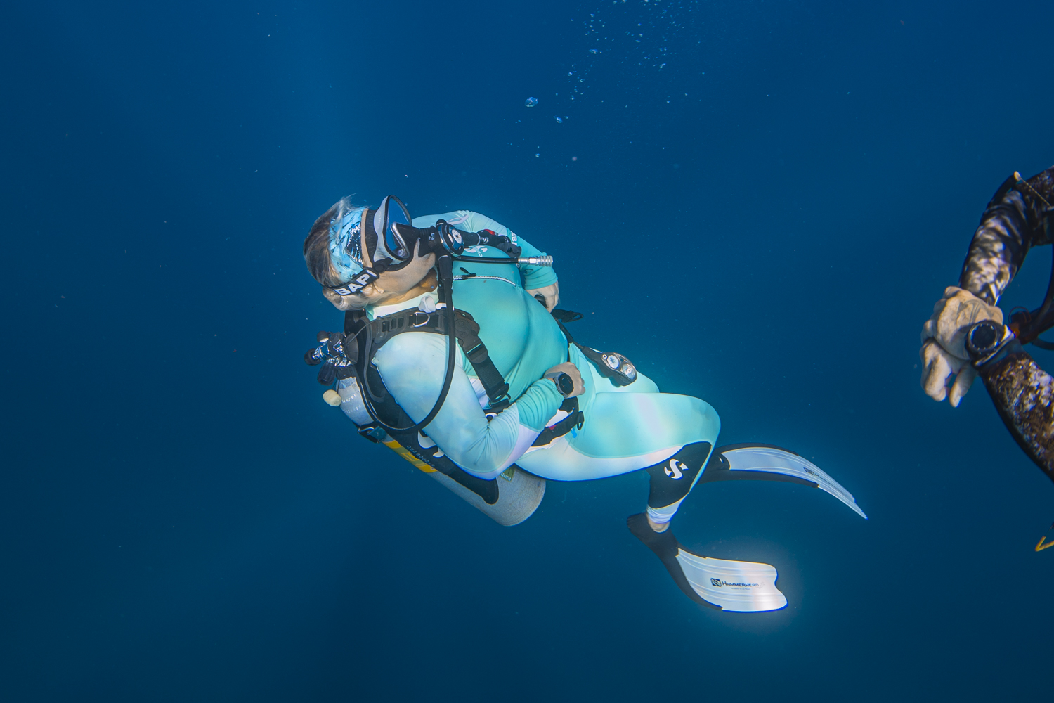 a man flying through the air while swimming in a body of water